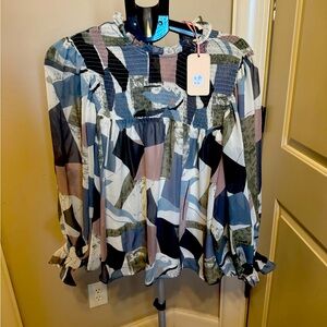 Abstract print mock neck long sleeve top featuring ruffle sleeves.